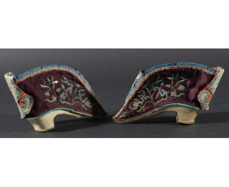PAIR OF CHINESE LADIES SILK SHOES, embroidered with silk, silver and gilt threads with scrolling foliage and swastikas, leath
