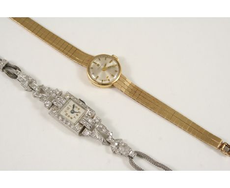 A LADY'S 9CT. GOLD WRISTWATCH BY TISSOT the signed circular dial with baton numerals, on an integrated 9ct. gold flexible bra