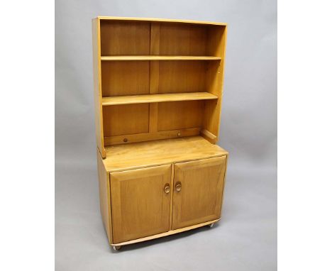 ERCOL BOOKCASE a light coloured elm bookcase from the Windsor Range, the top section with two adjustable shelves. The bottom 