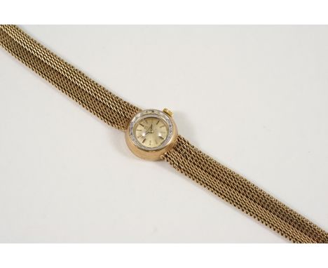 A LADY'S 9CT. GOLD WRISTWATCH BY OMEGA the signed circular dial with baton numerals, on an integrated 9ct. gold bracelet with