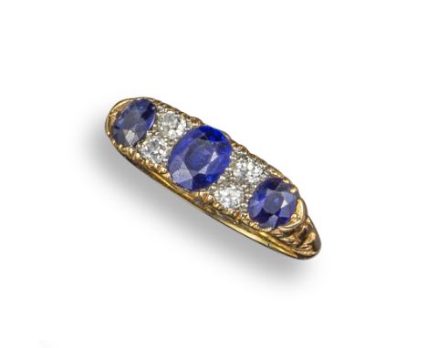 A sapphire and diamond half-hoop ring, set with three graduated oval-shaped sapphires separated with pairs of diamonds in gol