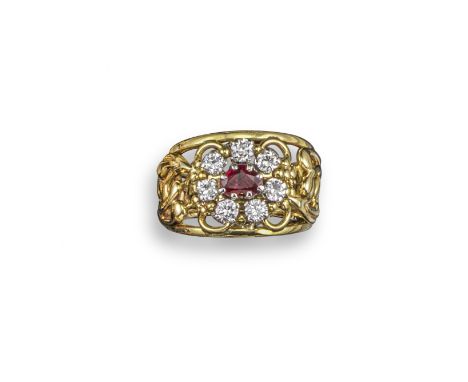 A ruby and diamond cluster ring by Valerie Pickford, the openwork gold ring with foliate scroll decoration and centred with a