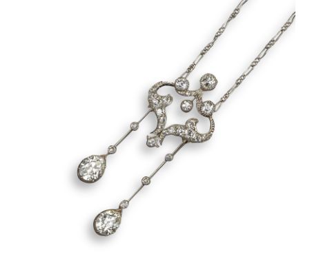 An Edwardian diamond lavalier, the scrolling upper section set with old circular-cut diamonds, suspending articulated knife-e