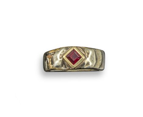 A ruby solitaire ring by Margaret Turner, set in yellow and white textured gold mount, maker's mark and London hallmarks for 
