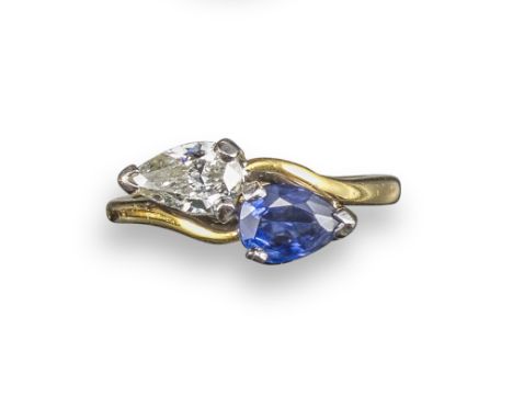 A sapphire and diamond crossover ring, set with a pear-shaped diamond weighing 0.60cts and a pear-shaped sapphire in 18ct yel