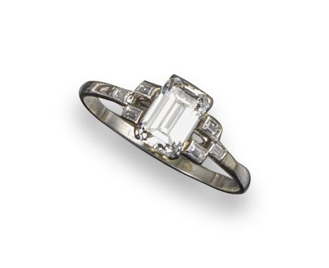 A diamond solitaire ring, the rectangular step-cut diamond weighs approximately 0.85cts and is set with three baguette-shaped