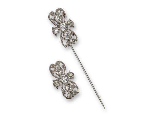 A diamond-set stick pin, of quatrefoil design, set overall with graduated old cushion-shaped diamonds in white gold, with a m