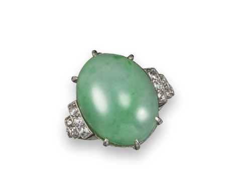 An early 20th century jade and diamond ring, the jadeite jade cabochon set within graduated diamond shoulders in platinum, si