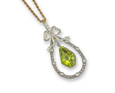 An Edwardian peridot and diamond pendant, the white enamel bow suspends an articulated hexagonal peridot within a border of r