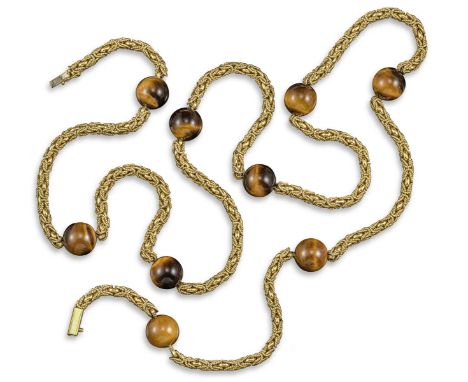 A yellow gold long chain, set with spherical tiger's eye beads between textured fancy-link sections in yellow gold, stamped 7