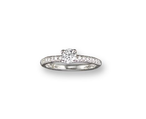 A diamond solitaire ring, the round brilliant-cut diamond weighs approximately 0.32cts, claw-set with further circular-cut di