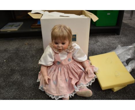 A modern Celia Doll Company bisque headed doll having fixed open eyes, clothed and boxed