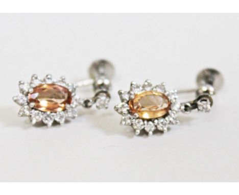 A pair of white metal diamond and citrine drop earrings, length 16mm each, gross wt. 4.8g.