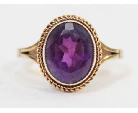 A yellow metal ring set with an amethyst coloured stone, gross wt. 2.8g, size N.