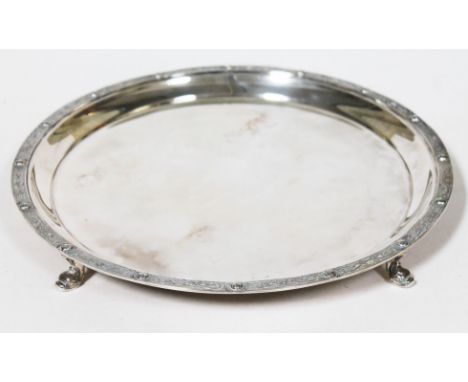 A Silver salver with Celtic style border and four scroll feet, Finnigan's Manchester, London 1937, diam. 26.5cm, wt. 20oz.