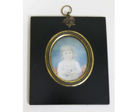 An early 19th Century miniature oval portrait on ivory depicting a young child within gilt metal mounted lacquered frame 11cm