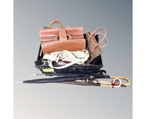 A crate containing assorted lady's handbags, vintage leather briefcases, parasols etc.