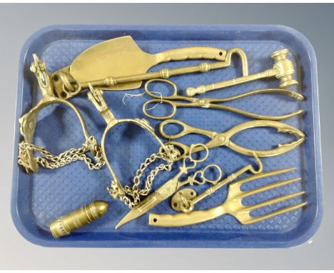 A tray containing assorted brass ware including a French lighter in the form of a bullet, companion pieces, auctioneer's gave