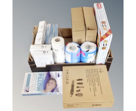 A box containing cooling gel pillows, sonic facial dermaplaning tools, kitchen roll, hot air multi-stylers, all parts new.