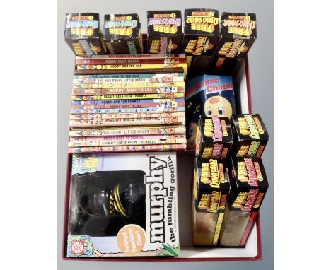 A box containing vintage Noddy books, Murphy tumbling gorilla, free to collect dinosaurs in packets.