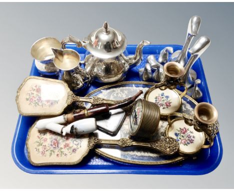 A tray containing a three piece plated tea service, a six piece vintage petit point dressing table set, a ceramic pipe, cigar