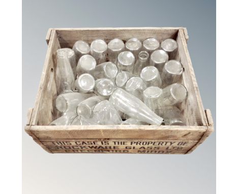 A vintage pine crate containing glass milk bottles 