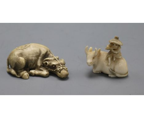 Two early 20th century Japanese ivory netsuke of an ox, one surmounted by a man