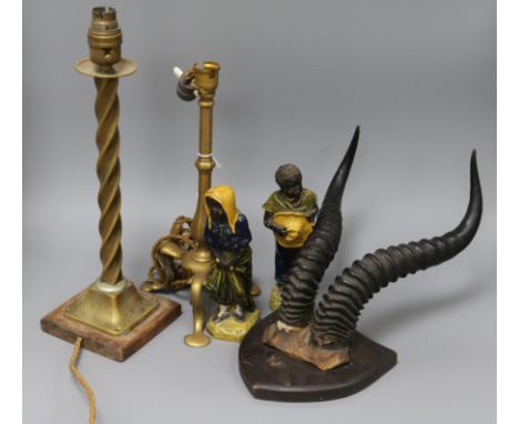 A pair of stoneware figures, mounted horns and two brass table lamps