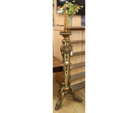 A Florentine style carved cream and gilt painted standard lamp, on dolphin supports Width of base 59cm