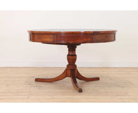 A late George III mahogany library drum table, early 19th century, with a green and gilt leather-lined top, above four real a