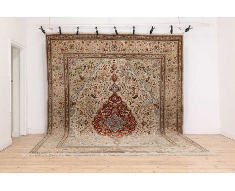 A Persian wool carpet,late 20th century, the field woven with a central floral medallion, within floral and foliate scrolls w