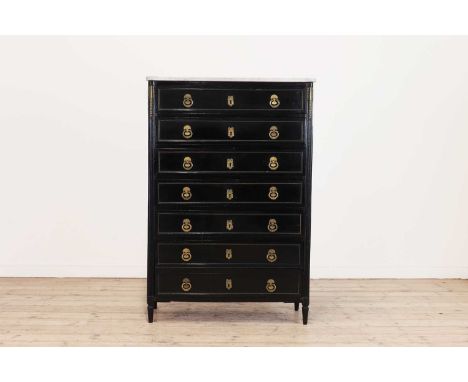 A Directoire ebonised semainier,with a white marble top above seven drawers with gilt handles, flanked by gilt-mounted fluted