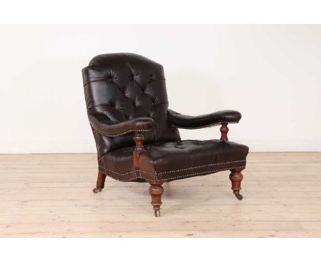 A late Victorian buttoned-leather armchair,c.1890, with curved open arms, raised on ring-turned front supports terminating in