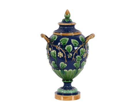 A MINTON MAJOLICA TWIN HANDLED URN AND COVERDATE CODE FOR 1864With acorn finial above the ivy clad blue groundImpressed marks