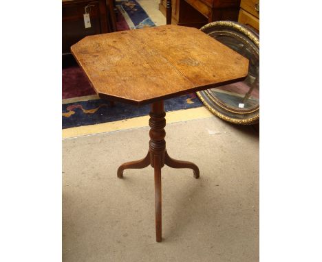 An early 19th Century oak and elm tripod table, the two plank top with cut off corners and tilt action raised on a turned ste