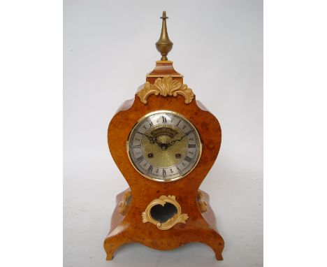 Peter Spicer: A Lousi XV style burr mulberry mantle clock, of bombe form, the brass circular dial with silvered chapter ring,