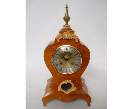 Peter Spicer: A Lousi XV style burr mulberry mantle clock, of bombe form, the brass circular dial with silvered chapter ring,