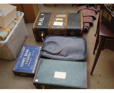 A small wooden bound trunk and three other suitcases. 