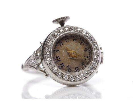 EDWARDIAN DIAMOND SET WATCH RINGthe bezel set with an enamel dial with diamond surround, on trifurcated diamond set shoulders