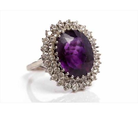AMETHYST AND DIAMOND CLUSTER RINGwith a large oval amethyst surrounded by brilliant cut diamonds, unmarked, size M-N