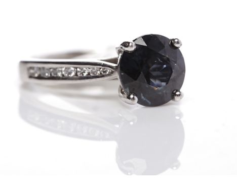 FANCY SAPPHIRE AND DIAMOND RINGthe round sapphire with black and blue tones of approximately 2.62 carats on diamond shoulders