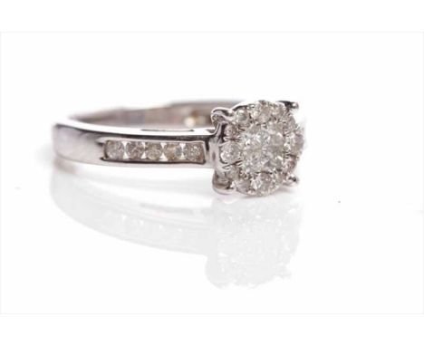 DIAMOND CLUSTER RINGset with four central square diamonds surrounded by brilliant cut diamonds, on diamond set shoulders, mar