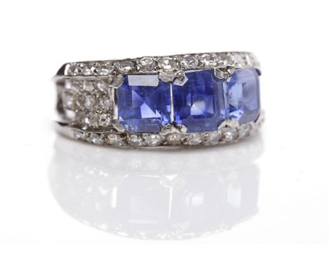 SAPPHIRE AND DIAMOND RINGset with three emerald cut sapphires, the central sapphire 6x5.7mm, in a diamond setting, with pierc