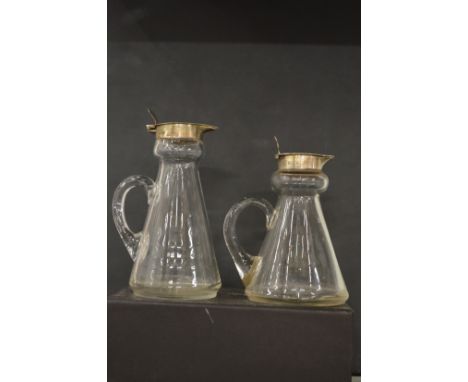 Two silver mounted glass whiskey tots and a similar item.
