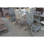 Three weathered teak folding garden armchairs.