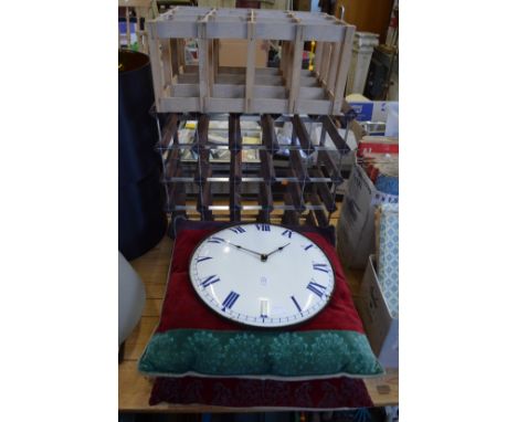 An enamel wall clock, two cushions and two wine racks.