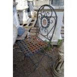 A set of four metal folding garden chairs.