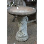 A reconstituted stone bird bath.