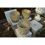 A set of three reconstituted stone circular planters.