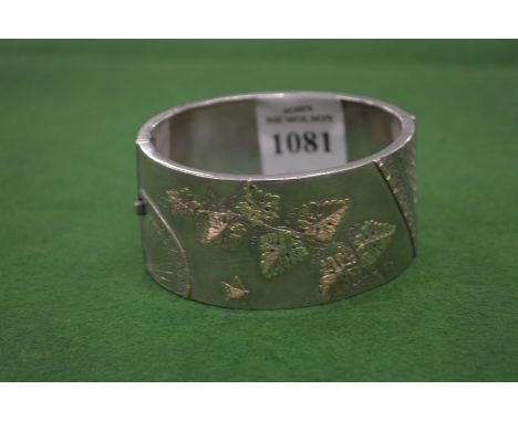 An engraved silver bangle.